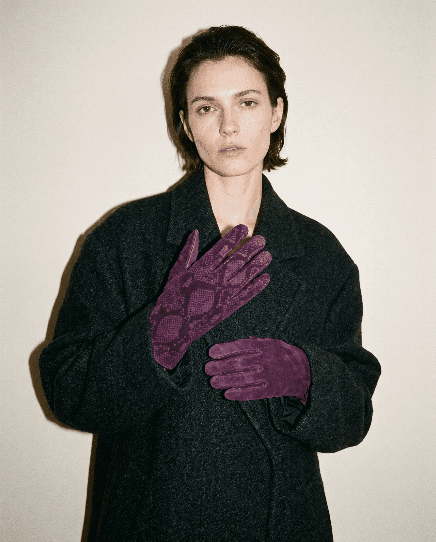 plum suede gloves printed with a python pattern worn with an oversized charcoal wool coat